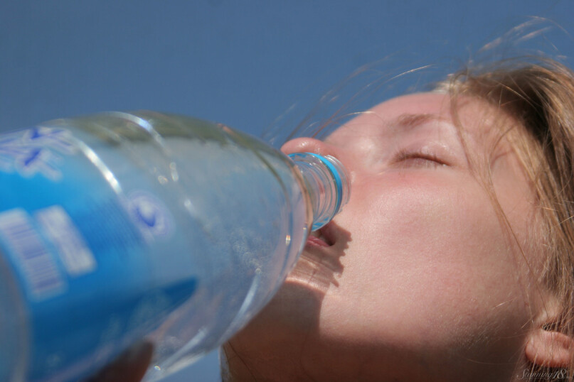 Nackte junge eifrige Schlampe Janet gießt Wasser durch ihren attraktiven Rahmen & Sonnenbäder außen