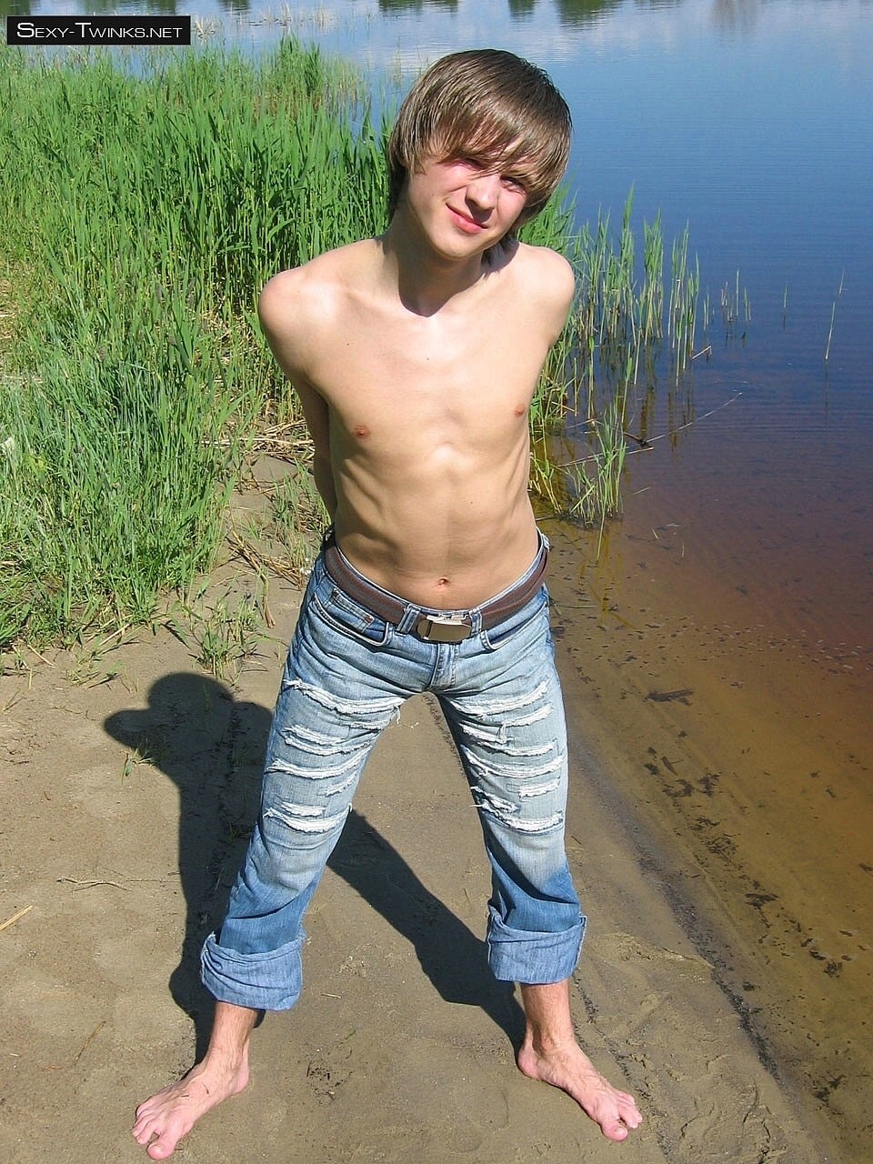 Gay beauty Mike strips naked by the river and plays with his hard cock