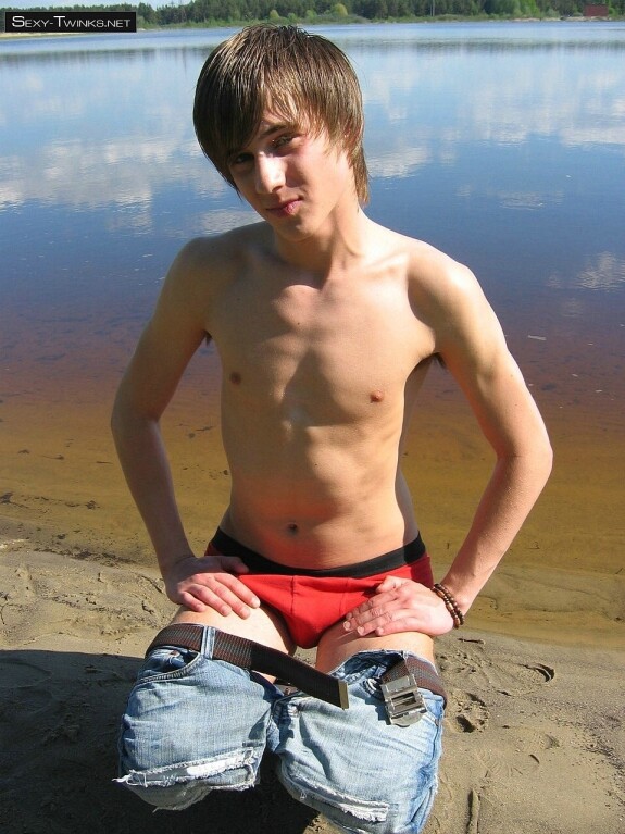 Gay beauty Mike strips by the river and plays with his hard dick