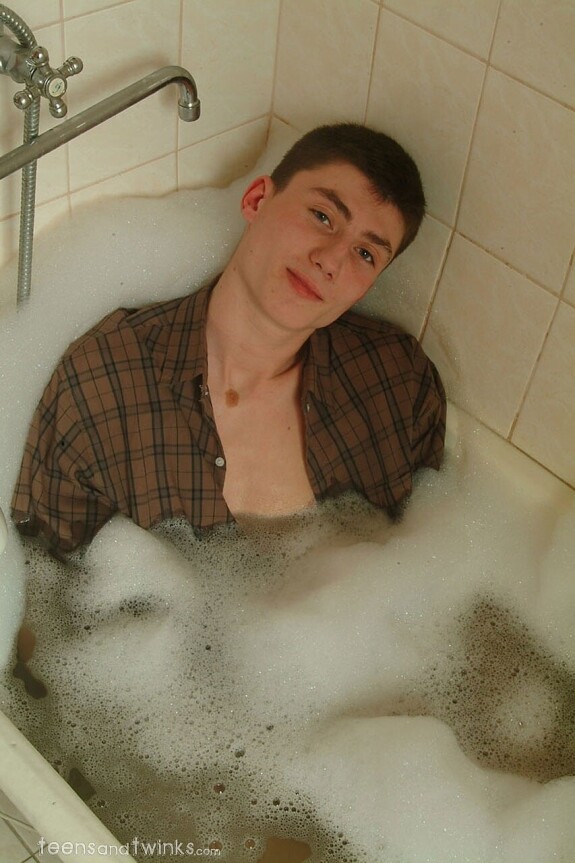 Petite skinny twink doffs his clothes and gets wet in a foamy bathtub