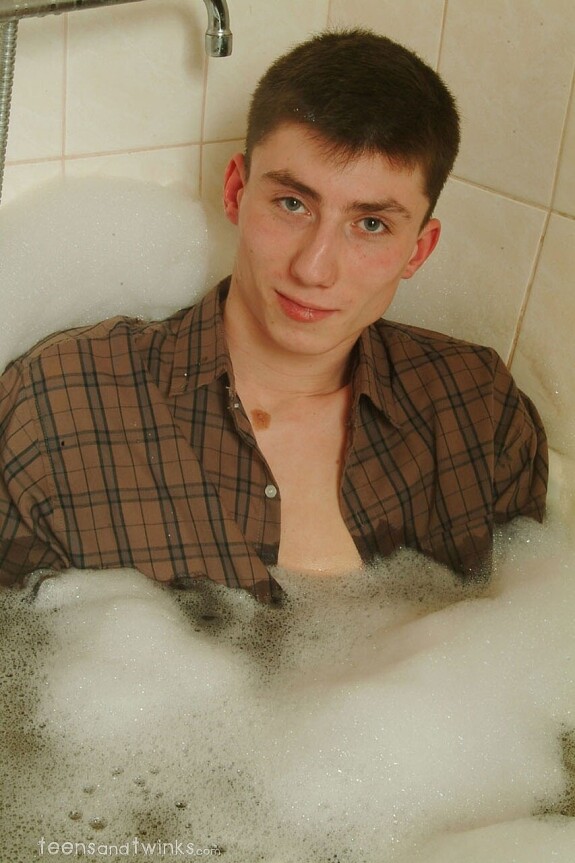 Petite skinny twink doffs his clothes and gets wet in a foamy bathtub