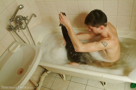 Petite skinny twink doffs his clothes and gets wet in a foamy bathtub