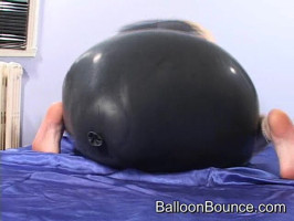 Sehr verspieltes Küken in schwarzem latex zieht sich an und reitet einen Ballon