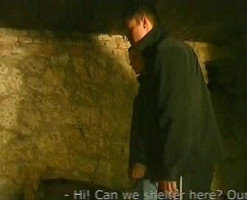 Trois hommes dominant un minet dans une cave sombre