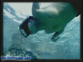 Sensual diver in blue undies is going topless underwater