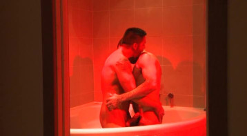 Trozo musculoso le ofrece a su amigo una mamada agradable bajo la luz rosada