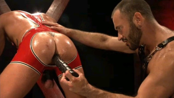 Dominatore sensuale infila un dildo nel culo del suo schiavo