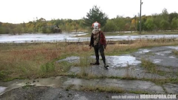 A horror clown mocks schoolgirl in an deserted building