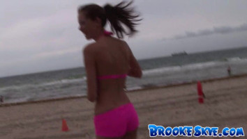 Sporty Brooke Skye poses at the seashore in brilliant red bikinis