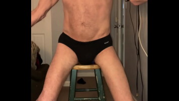 Pelvic Stretching on Stool with crimson balls and Black briefs and socks