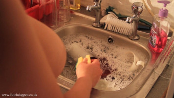 Busty chained chick is washing dishes whilst been absolutely bare