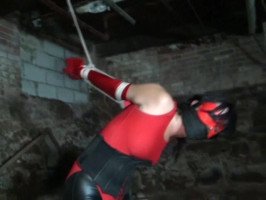 Slave in crimson and black is pressured into an lousy position