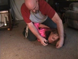 Young brunette in a shirt receives tortured through her kidnapper