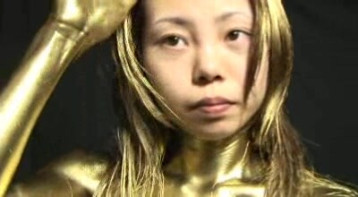 Beautiful bare Japanese paints herself with golden colour